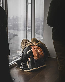 Due, donna, seduta, davanti, pannello di vetro, Marrone, parquet, analizzare, cercare, guardare, persona, finestra, zaino, moda, persone reali, in casa, stili di vita, persone, vetro - materiale, pavimentazione, giorno, uomini, interno di casa, capi di abbigliamento, adulto, lunghezza intera, trasparente, pavimento in legno, solidarieta, questioni sociali, 2K, CC0, dominio pubblico, privo di copyright
