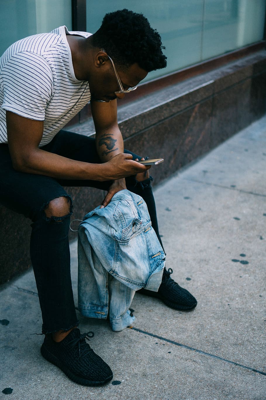 home assegut, costat, celebració, telèfon, home, seient, al costat, telèfon mòbil, homes, gent, missatge de text, una persona, assegut, telèfon intel·ligent, ètnia africana, a l'aire lliure, mascles, adult jove, adult, descendència africana, roba casual, estils de vida, escena urbana, tecnologia, vida de ciutat, un sol home, tecnologia sense fils, persones reals, longitud completa, comunicació, home jove, activitat d'oci, utilitzant el telèfon, dispositiu d’informació portàtil, adolescència, nois adolescents, adolescent, 5K