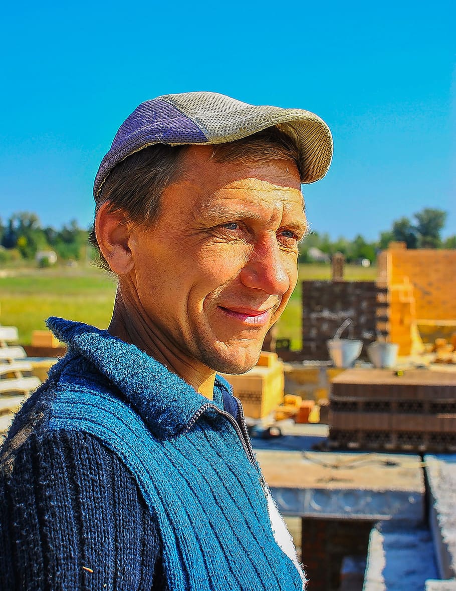 constructor, treballador, home, construcció, retrat, adult gran, una persona, blau, estils de vida, somrient, roba, adult, activitat d'oci, mirant la càmera, persones reals, dia, tirada al cap, naturalesa, barret, centrar-se en primer pla, emoció, arrugat, roba calenta, 2K