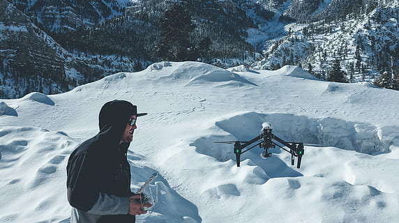 man, wearing, pull-over jacket infront, black, quadcopter, snow field mountain, pull, jacket, infront, snow field, mountain, snow, winter, outdoors, nature, adult, men, people, adults Only, one Person, cold - Temperature, color Image, vacations, caucasian Ethnicity, day, image Type, image Technique, time Of Day, season, cold temperature, real people, leisure activity, lifestyles, beauty in nature, adventure, white color, holiday, sport, trip, clothing, warm clothing, snowcapped mountain, mountain range, extreme weather, 2K, CC0, public domain, royalty free
