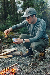 selective, focus photography, man, holding, lit, matchstick, outdoors, ducking, safety, match, forest, camping, fire, tree, outdoor, person, flame, watch, hat, boot, woods, adventure, camp, young, male, guy, green, one person, young adult, real people, young men, lifestyles, clothing, leisure activity, nature, casual clothing, men, day, wireless technology, technology, land, looking, bonfire, 5K, CC0, public domain, royalty free