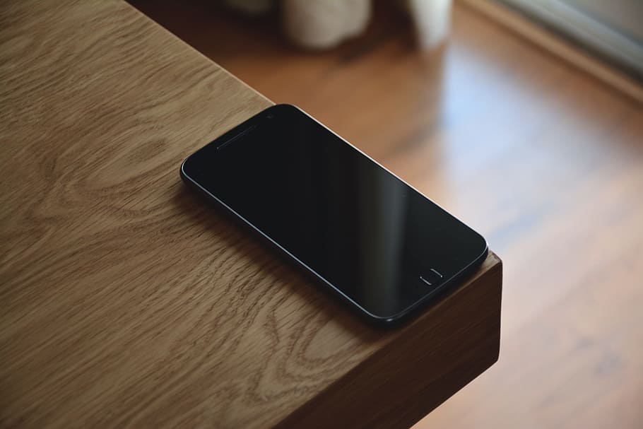 Handy, Mobiltelefon, Telefon, Handy, Kommunikation, Anruf, Text, Gadget, Technologie, Smartphone, Android, kabellose Technologie, tragbares Informationsgerät, Verbindung, Tabelle, Mobiltelefon, Holz - Material, High Angle View, Bildschirm, drinnen, Berührungsempfindlicher Bildschirm, Nahansicht, Gerätebildschirm, Stillleben, schwarze Farbe, keine Leute, digitale Tablette, Fokus auf den Vordergrund, Holzmaserung, 5K
