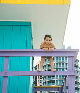 niño, playa, posando, juguetón, persona, gente, verano, feliz, vacaciones, divertido, joven, al aire libre, naturaleza, linda, infancia, activo, pequeño, felicidad, alegría, ocio, mirando a la cámara, una persona, sonriente, retrato, Sólo para adultos, vista frontal, gente real, estilos de vida, adulto joven, arquitectura, actividad de ocio, estructura construida, emoción, exterior del edificio, día, barandilla, ropa casual, inocencia, 4K