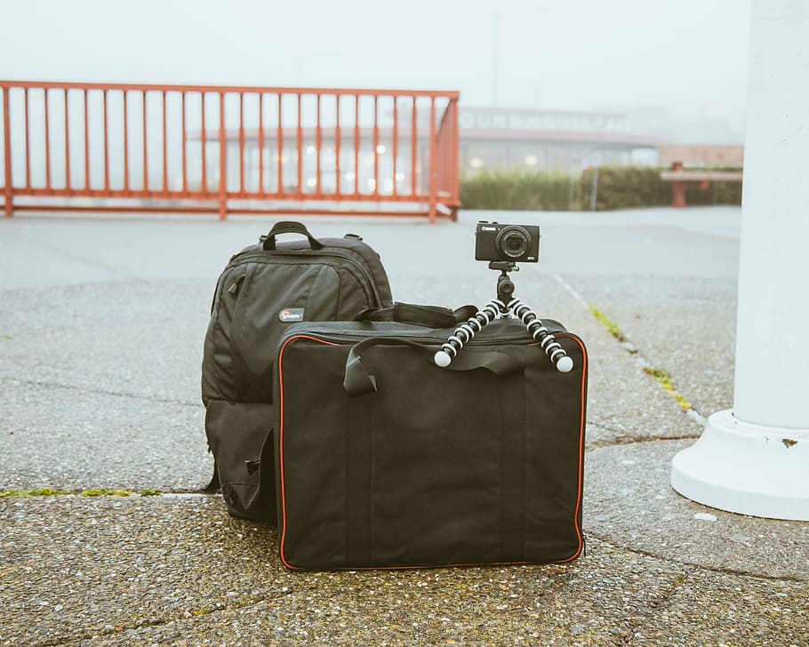 Kamera, montiert, Stativ, oben, Gepäcktasche, schwarz, Tasche, draußen, Verpackung, Rucksack, organisiert, Selfie, Bahnhof, Pflaster, Gepäck, reisen, Verlassen, verpackt, Pack, erkunden, Koffer, Reise, keine Leute, die Architektur, Abwesenheit, Tag, Fokus auf den Vordergrund, gebaute Struktur, fahrbares Gepäck, Transport, Stadt, Natur, Stillleben, Sicherheit, schwarze Farbe, persönliches Accessoire, 2K