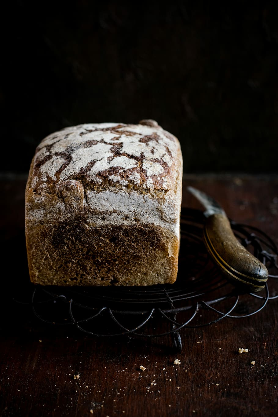 primer pla, foto, al forn, pa, pastisseria, al costat, ganivet, cocció, prestatge, menjar i beguda, menjar, frescor, a l'interior, natura morta, cap gent, taula, llest per menjar, material de fusta, tir de l'estudi, marró, fons negre, benestar, menjar dolç, alimentació saludable, indulgència, llesca de pa, temptació, 5K