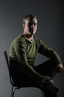 masculino, homens, cara, humano, homem, sentado, comprimento de três quartos, dentro de casa, uma pessoa, tiro do estúdio, cadeira, roupa casual, assento, adulto jovem, cinzento, vista frontal, fundo cinza, homens jovens, olhando para a câmera, retrato, estilos de vida, roupas, pessoas reais, fundo preto, 5K, CC0, domínio público, royalty free