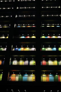 black concrete building, architecture, building, infrastructure, structure, establishment, apartment, terrace, veranda, color, light, dark, night, illuminated, built structure, pattern, no people, low angle view, lighting equipment, glowing, building exterior, window, full frame, backgrounds, city, modern, glass - material, light - natural phenomenon, in a row, ceiling, nightlife, 5K, CC0, public domain, royalty free