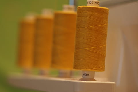 braune Fadenrolle, Faden, Spule, Nähen, Overlocker, Baumwolle, Polyester, Garn, Maschine, Kleidung, Textil-, Stich, Kunst, Handarbeit, Handwerk, Schneiderei, Serger, Gelb, Farbe, Nahansicht, keine Leute, drinnen, Fokus auf den Vordergrund, Kunst und Handwerk, selektiver Fokus, Stillleben, in einer Reihe, Kreativität, Holz - Material, Papier-, Container, Tag, Gruppe von Objekten, Ausrüstung, Industrie, 2K, CC0, gemeinfrei, lizenzfrei