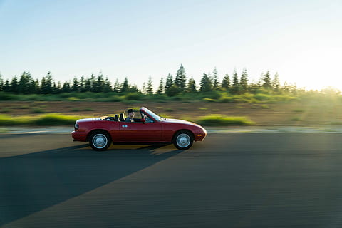persona, guida, rosso, convertibile, coupe, in esecuzione, calcestruzzo, strada, convertibile rosso, strada cementata, auto, mezzi di trasporto, all'aperto, modalità di trasporto, veicolo terrestre, viaggio su strada, auto sportiva, viaggio, velocità, immagine a colori, nessuno, modo di trasporto, movimento sfocato, veicolo a motore, movimento, albero, giorno, cielo, pianta, natura, in movimento, cielo sereno, luce del sole, 5K, CC0, dominio pubblico, privo di copyright
