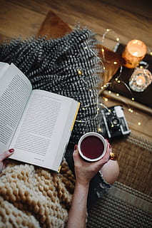 woman drinking tea, reading book, Woman, drinking, tea, female, home, book, reading, time, pillows, comfortable, cozy, hygge, fruit tea, fairy lights, drink, coffee - Drink, human Hand, table, cup, women, people, food, human body part, one person, food and drink, high angle view, real people, holding, refreshment, hand, indoors, coffee, lifestyles, leisure activity, coffee cup, unrecognizable person, finger, 5K