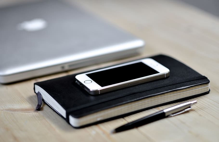 iphone daurat 5, 5s, superior, negre, llibre de llibres, escriptori, quadern, telèfon, cel·la, mòbil, portàtil, bolígraf, espai de treball, treballar, oficina, net, netejar, ordenat, organitzat, comunicació, smartphone, poma, Internet, sense fils, telèfon intel·ligent, telèfon mòbil, tecnologia, negocis, taula, equipament, material de fusta, mobilitat, tecnologia sense fils, connexió, dispositiu d’informació portàtil, primer pla, enfocament selectiu, natura morta, cap gent, pantalla, pantalla del dispositiu, portabilitat, a l'interior, centrar-se en primer pla, dos objectes, equips de telecomunicacions, 5K