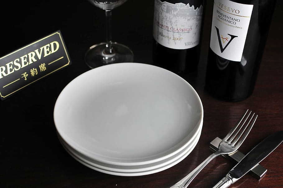 plade, ved siden af, vinflasker, reserveret siddepladser, fad, restaurant, gaffel, mad og drikke, bord, spise redskaber, indendørs, husholdningsudstyr, køkkenredskaber, mad, bordkniv, ingen mennesker, kniv, forretning, tekst, salt shaker, forfriskning, glas, indstilling, alkohol, spisning, aftensmad, porcelæn, 4K