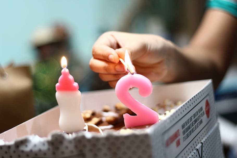 persona, il·luminació, nombre, 2, vela, celebració, marró, coincidir, pal, foc, encès, mà, aniversari, donut, 21, cremar, Caixa, dit, festa, mà humana, part del cos humà, primer pla, enfocament selectiu, a l'interior, una persona, menjar i beguda, cremant, flama, adult, menjar dolç, mig adult, espelmes d'aniversari, inserció, 5K