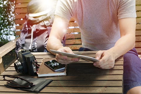 uomo, persona, occhiali da sole, mani, zaino, telecamera, casuale, cellulare, detenzione, taccuino, smartphone, tavoletta, tecnologia, indossare, sedia di legno, tavolo di legno, una persona, Sezione centrale, lavoro, adulto, abbigliamento casual, persone reali, in casa, giorno, uomini, tavolo, luce del sole, stili di vita, occupazione, vista frontale, legno - materiale, preparazione, attrezzatura, 4K