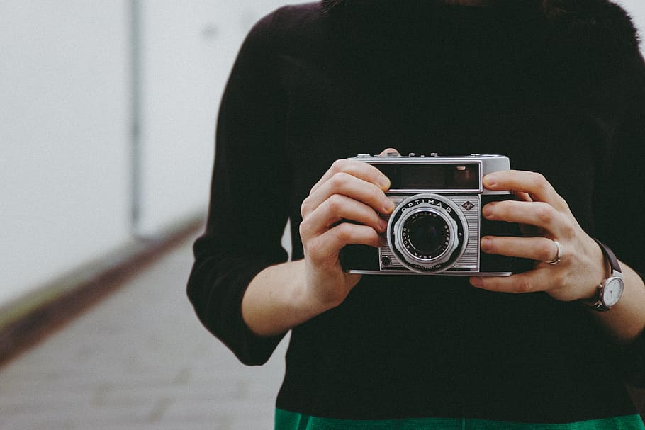 deținere, epocă, aparat foto, fată, concepte și idei, obiecte, oameni, aparat de fotografiat - echipament fotografic, fotograf, o persoana, femei, Sesiuni foto, adult, în aer liber, fotografii tematice, hobby-uri, etnie caucaziană, de modă veche, stil retro, tânăr adult, stiluri de viață, tehnologie, activitate, oameni adevărați, echipament fotografic, Activitatea de agrement, să se concentreze asupra primelor elemente, vedere din față, ocupaţie, midsection, haine casual, camera digitala, fața confuză, 4K