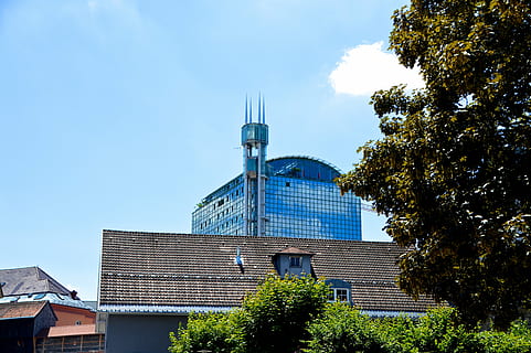 Wolkenkratzer, Aufzug, Stadt, Hotel, Turm, spitz, Himmel, Blau, Kempten, Bayern, die Architektur, Glasfront, Turmhaus, Glas, Spiegeln, Wolke, Stadt zu Hause, Dächer, Innenstadt, Stadtplanung, leben und arbeiten, gebaute Struktur, Gebäudehülle, Gebäude, Baum, Pflanze, Natur, keine Leute, Tag, Bürogebäude außen, Flachwinkelansicht, draußen, Fenster, wolke - himmel, modern, große Höhe, 5K, CC0, gemeinfrei, lizenzfrei