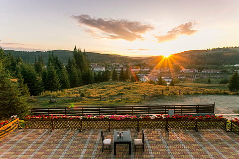 photography, table, two, chairs, beside, bench, outside, golden, hour, piece, garden, sunset, sunlight, sunrise, tree, plant, green, grass, lawn, mountain, highland, landscape, nature, flower, chair, fence, cloud, sky, floor, sun, cloud - sky, outdoors, scenics, no people, architecture, built structure, beauty in nature, high angle view, tranquility, scenics - nature, lens flare, building exterior, orange color, sunbeam, roof, 4K