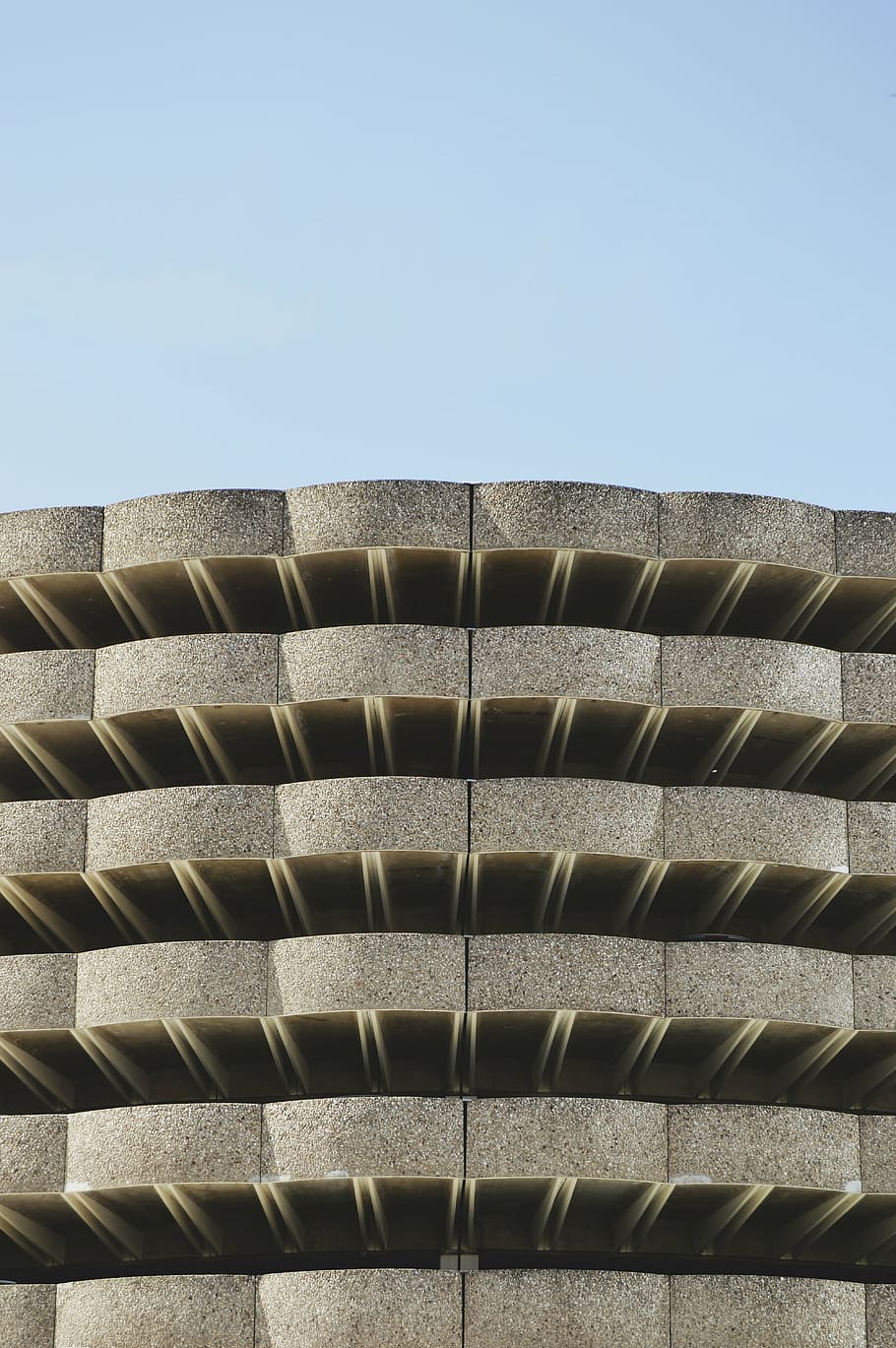 edifici de formigó gris, arquitectura, edifici, infraestructura, estructura, establiment, apartament, finestres, condomini, hotel, núvols, cel, dia, vista d’angle baix, exterior de l'edifici, a l'aire lliure, cel clar, cap gent, primer pla, estructura construïda, patró, còpia espai, llum solar, naturalesa, metall, repetició, característica arquitectònica, funció de construcció de parets, blau, assolellat, 5K