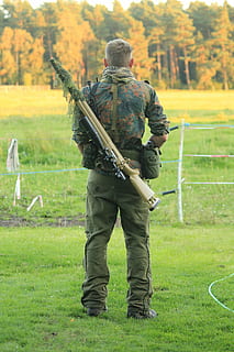 man, bärande, gevär, stående, staket, flytta, avlägsen, manlig, vapen, sluttid, golv, äng, luft, mjuk, hela, kropp, mänsklig, grön, i, ung, Kolla på, växt, landa, riktiga människor, fält, natur, dag, gräs, människor, män, Kläder, träd, grön färg, full längd, utomhus, sport, enhetlig, fokusera på förgrunden, pistol, bakåtsikt, regering, 5K, CC0, offentligt domän, royaltyfria