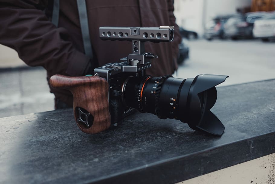 sort, dslr kamera, top, bord, person i fronten, kamera, linse, tech, udstyr, fotograf, mand, han-, væg, len, kameraudstyr, filme, Sony Alpha, fotografering temaer, teknologi, kamera - fotografisk udstyr, en person, fotografisk udstyr, rigtige mennesker, beskæftigelse, digitalt kamera, fokus på forgrunden, herrer, tæt på, menneskelig hånd, objektiv - optisk instrument, hånd, dag, menneskelig kropsdel, aktivitet, sort farve, 4K