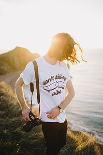 durdle door, shallow, focus photography, man, holding, dslr camera, mountain, view, large, body, water, daytime, photographer, camera, tee, tshirt, dont kill my vibe, outdoors, one Person, sport, women, healthy Lifestyle, people, exercising, lifestyles, nature, females, adult, young Adult, sports Clothing, caucasian Ethnicity, recreational Pursuit, leisure Activity, copy Space, jogging, summer, adults Only, sunlight, standing, mid adult, one woman only, real people, casual clothing, three quarter length, sky, day, land, sea, text, focus on foreground, communication, hairstyle, teenager, 2K, CC0, public domain, royalty free