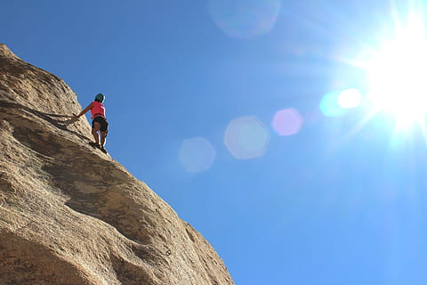 persona, rosa, superiore, nero, montagna di fondo inferiore, scalatore, roccia, parete, verticale, montagna, sport, estremo, avventura, all'aperto, attivo, natura, arrampicata, cielo, pietra, alpinista, alto, scogliera, sfida, altezza, una persona, attività, sport estremi, Inquadratura dal basso, luce del sole, roccia - oggetto, copia spazio, solido, riflesso lente, uno stile di vita sano, attività di svago, sforzo, 2K, CC0, dominio pubblico, privo di copyright