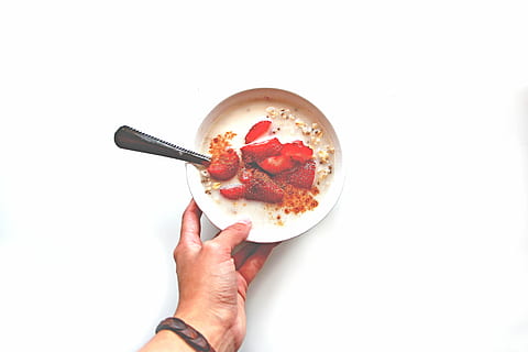 person, holding, bowl, dessert, sliced, strawberry, white, ceramic, oatmeal, strawberries, fruits, nuts, breakfast, food, spoon, hand, healthy, human body part, human hand, one person, food and drink, white background, people, only women, one woman only, studio shot, indoors, freshness, directly above, kitchen utensil, eating utensil, finger, human finger, healthy eating, copy space, 5K