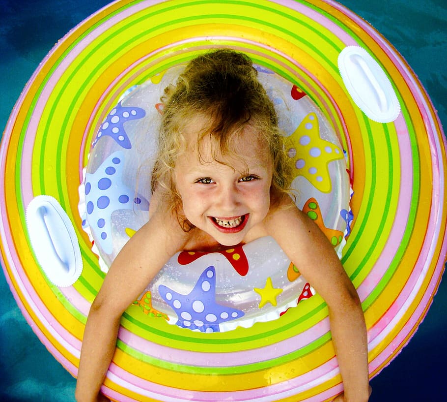 oppustelige, cirkel, vand, pool, pige, baby, smilende, krøller, lykke, barn, barndom, kun børn, kigger på kameraet, glad, sjovt, nydelse, multi farvet, emotion, fritidsaktivitet, piger, forfra, en person, portræt, legeplads, spille, høj vinkel visning, uskyld, positive følelser, udendørs legepladsudstyr, 2K