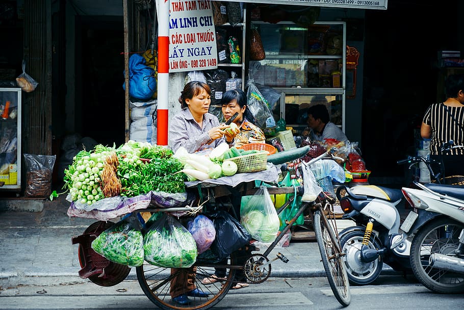 dona, tallar, vegetals, bicicleta, stand, botiga, negre, bicicleta holandesa, portar, assortit, verdures, obert per a empreses, carrer, gent, editorial, escena urbana, mercat, asia, vida de ciutat, Sud-est asiàtic, venda, menjar, venedor del mercat, venedor, ciutat, cultures, venda al detall, a l'aire lliure, negoci petit, persones reals, dones, adult, transport, homes, grup de persones, negocis, estils de vida, a la venda, roba casual, manera de transport, longitud completa, arquitectura, persones incidentals, visualització al detall, 5K