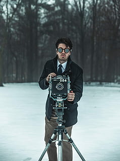 mand, stående, foran, sort, kamera, stå, omgivet, træer, selektiv, fokus fotografering, iført, frakke, ved brug af, grå, stativ, høj, dagtimerne, træ, Skov, skæg, dragt, en person, rigtige mennesker, livsstil, unge mænd, teknologi, kamera - fotografisk udstyr, fotografering temaer, ung voksen, fokus på forgrunden, fotografisk udstyr, forfra, fritidsaktivitet, natur, briller, tre kvart længde, plante, dag, aktivitet, udendørs, digitalt kamera, fotograf, varme tøj, 4K, CC0, offentligt domæne, royaltyfrie
