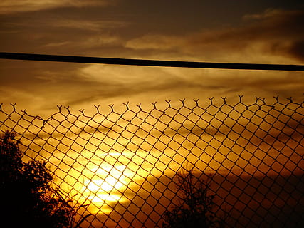 Soleil, lumière, ciel, paysage, des nuages, rayon de lumière, rayon de soleil, image, la photographie, bar, les bars, nuages ​​noirs, Orange, rouge, clôture, fil barbelé, grillage, câble, frontière, métal, la grille, prison, barrière, le coucher du soleil, nuage - ciel, Sécurité, la nature, protection, treillis métallique, personne, silhouette, crépuscule, architecture, lumière du soleil, bâtiment, exclusion, alliage, acier, 4K, CC0, domaine public, libre de droits