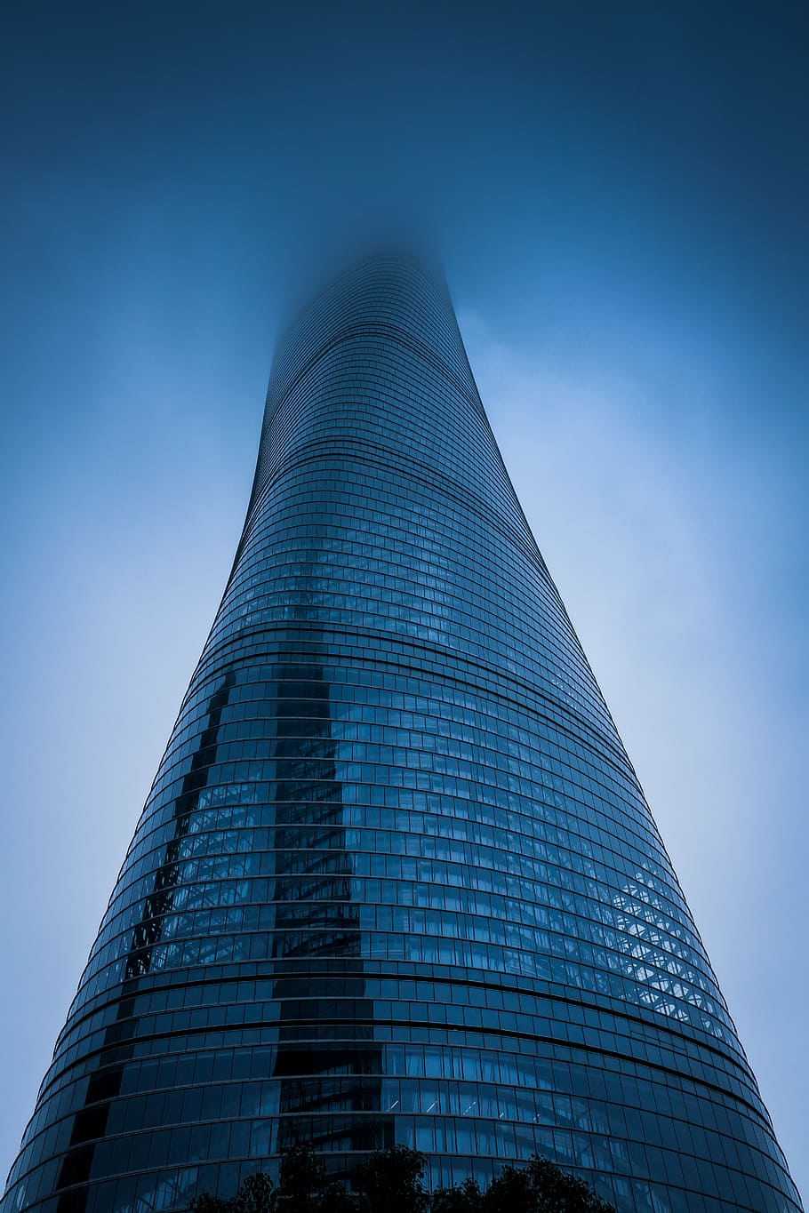 baix, fotografia d'angle, gris, construcció de mur cortina, cobert, boira, fotografia d'angle baix, retorçat, vidre, de gran alçada, edifici, gratacels, cel, núvols, blau, arquitectura, estructura construïda, exterior de l'edifici, vista d’angle baix, ciutat, alta - alta, modern, destinacions de viatge, exterior d’edifici d’oficines, cap gent, torre, viatjar, turisme, dia, reflexió, 5K