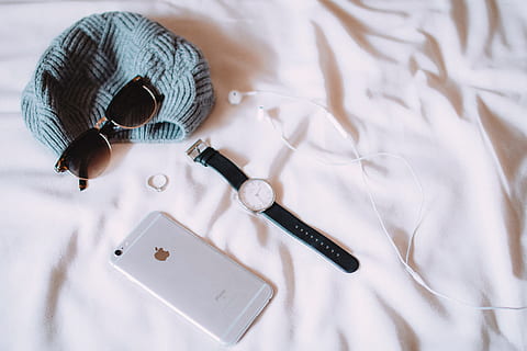 round silver-colored analog, watch, black, strap, iphone, mobile, smartphone, bed, sheets, headphones, earbuds, sunglasses, hat, fashion, indoors, high angle view, no people, textile, still life, furniture, close-up, make-up brush, studio shot, sheet, arts culture and entertainment, white color, bedroom, linen, art and craft, pen, craft, domestic room, table, 5K, CC0, public domain, royalty free