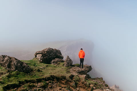 hombre, vistiendo, naranja, sudadera con capucha, en pie, acantilado, tiempo de día, pull-over, capucha, naturaleza, excursionismo, montaña, al aire libre, gente, aventuras, paisaje, viaje, scenics, mochila, un solo hombre, sólo hombres, vista trasera, una persona, Sólo para adultos, longitud total, hombres, rock, paisajes - naturaleza, roca - objeto, actividad de ocio, belleza en la naturaleza, sólido, niebla, cielo, tranquilidad, escena no urbana, actividad, día, mirando a la vista, contemplación, 5K, CC0, dominio público, libre de derechos