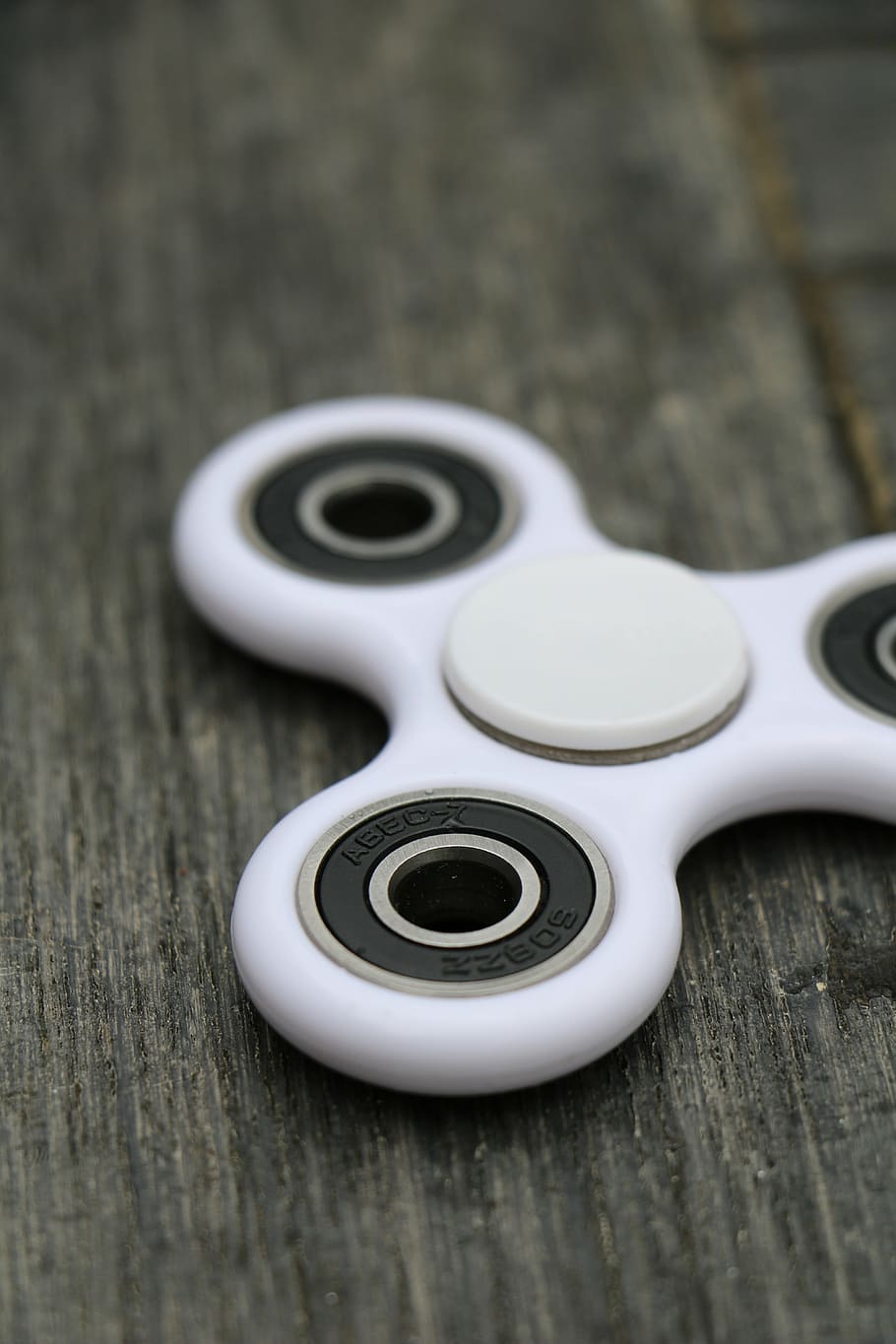 blanc, tri-spinner fidget spinner, agitador de moviments, inquiet, spinner, joguina, inquietant, adhd, 2017, tendència, jugar, tir de l'estudi, a l'interior, primer pla, cap gent, dia, fons negre, taula, natura morta, material de fusta, metall, enfocament selectiu, centrar-se en primer pla, cercle, forma geomètrica, forma, vista d’angle alt, grup d'objectes, fet per l'home, tecnologia, disseny, objectes fets per l’home, color plata, aliatge, roda, 5K