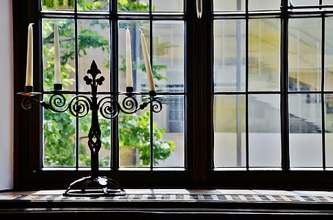 black, steel candelabra, window, candles, candlestick, candle holders, candlelight, window sill, indoors, glass - material, transparent, home interior, day, no people, architecture, building, domestic room, flooring, window frame, house, built structure, entrance, nature, design, door, luxury, 4K, CC0, public domain, royalty free