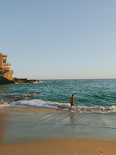 uomo, arancia, carro armato, superiore, nero, abito da scatti, in piedi, blu, mare, giorno, canotta, scatti, attrezzatura, mare blu, spiaggia, costa, acqua, onda, natura, cielo, roccia - oggetto, sabbia, all'aperto, Paesaggi, paesaggio, nessuno, cielo sereno, orizzonte sull'acqua, terra, scenics - natura, bellezza nella natura, orizzonte, copia spazio, persone reali, movimento, attività di svago, una persona, stili di vita, 2K, CC0, dominio pubblico, privo di copyright