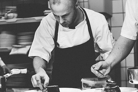 grayscale photo, man, wearing, apron, chef, kitchen, male, professional, occupation, profession, commercial kitchen, restaurant kitchen, work, dish, plate, people, service, preparation, preparing, culinary, catering, restaurant, cooking, cook, uniform, cuisine, job, adult, hotel, standing, only men, indoors, adults only, one man only, skill, working, men, holding, food and drink, two people, preparing food, food, real people, business, concentration, 4K