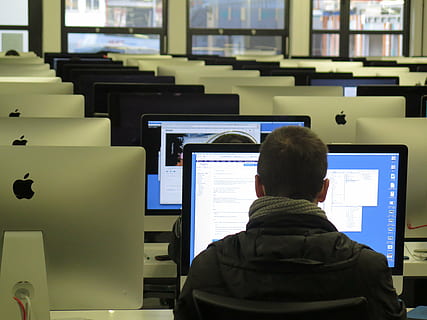 hombre, vistiendo, negro, parte superior, frente, plata imac, trabajo, colegio, enseñar, educación, computadora, tecnología, monitor de computadora, gente, negocio, adentro, hombres, Internet, vista trasera, equipo de computadora, una persona, sentado, gente real, disparo a la cabeza, adulto, trabajando, usando la computadora, ocupación, PC de escritorio, mueble, escritorio, 4K, CC0, dominio público, libre de derechos