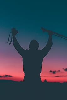 silhouette photo, man, holding, tripod, dslr camera, people, guy, ravel, mountain, climbing, hike, sunset, silhouette, clouds, sky, camera, photographer, human arm, arms raised, limb, human body part, arms outstretched, one person, standing, adult, real people, leisure activity, lifestyles, three quarter length, rear view, men, orange color, nature, women, carefree, 5K, CC0, public domain, royalty free