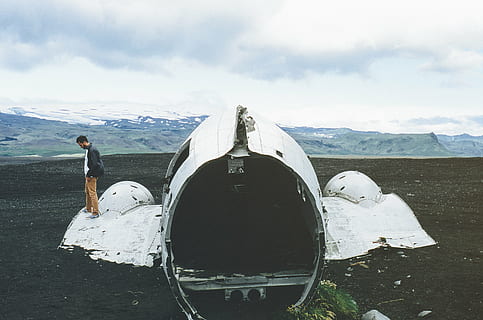 man, standing, wrecked, aircraft, wearing, brown, pants, white, machine, near, body, mountain, daytime, airplane, crash, wreck, damange, dirt, mountains, hills, valleys, snow, peaks, sky, clouds, one person, one man only, adults only, day, outdoors, adult, only men, people, cloud - sky, nature, full length, air vehicle, environment, leisure activity, men, real people, beauty in nature, water, transportation, snowcapped mountain, 2K, CC0, public domain, royalty free