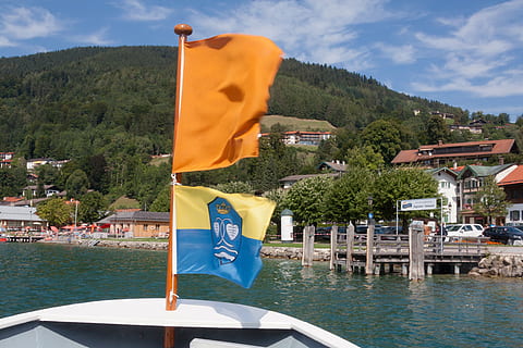 ship, ferry, boot, bug, water, lake, flag, orange, yellow, blue, coat of arms, gmund, tegernsee, pier, piles, beach, strandbad, upper bavaria, holiday, recovery, tree, plant, nature, nautical vessel, sky, mode of transportation, transportation, patriotism, architecture, building exterior, built structure, no people, day, mountain, cloud - sky, waterfront, outdoors, 4K, CC0, public domain, royalty free