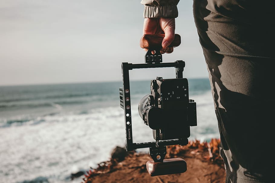 persona que sosté la càmera, selectiu, focalitzar la fotografia, persona, celebració, càmera, cardanal, de cara, mar, equipament, platja, oceà, aigua, temes de fotografia, terra, tecnologia, cel, naturalesa, càmera - equip fotogràfic, una persona, dia, activitat, ocupació, centrar-se en primer pla, secció mitjana, horitzó, trípode, horitzó sobre l’aigua, rodatge, càmera digital, fotògraf, 1080P