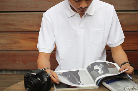 moda, uomo, persona, telecamera, libro, scrivania, elettronica, mobilia, in casa, analizzare, cercare, guardare, carta, lettura, camera, tavolo, indossare, vista frontale, detenzione, una persona, occupazione, in piedi, uomini, dalla vita in su, tecnologia, adulto, Sezione centrale, temi fotografici, macchina fotografica - attrezzatura fotografica, giovane adulto, attrezzatura, lavoro, giorno, 2K, CC0, dominio pubblico, privo di copyright