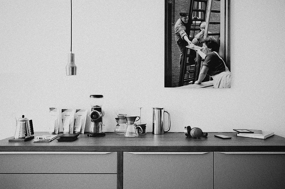 foto in scala di grigi, credenza, lampada a sospensione, cucina, attrezzatura, manifesto, design, casa, mobilia, utensili da cucina, interno, moderno, domestico, contemporaneo, bianco e nero, una persona, in casa, persone reali, tavolo, attrezzature domestiche, utensile da cucina, stili di vita, stanza domestica, in piedi, seduta, occupazione, pubblicazione, uomini, lavoro, tecnologia, ufficio, specchio, lunghezza intera, 4K
