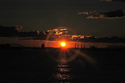 tramonto, impostazione, sole, alone, anello, splendore, ambientazione, sole, alone, squillare, arancia, crepuscolo, mare, riflessione, nuvole, cielo, notte, all'aperto, mezzi di trasporto, silhouette, acqua, natura, illuminato, bellezza nella natura, nessuno, scenics - natura, architettura, struttura costruita, lungomare, nuvola - cielo, esterno dell'edificio, colore arancione, riflesso lente, 2K, CC0, dominio pubblico, privo di copyright