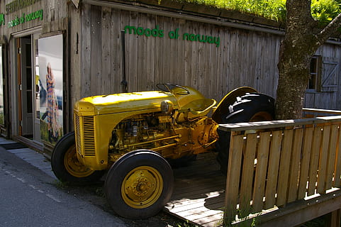 ciągniki, historycznie, ciągnik, oldtimer, stary, klasyczny, pojazd, nostalgiczny, złoty ciągnik, złoto, promienie, wyprzedaż, marketing, magnes klienta, dojrzały, architektura, transport, dzień, zbudowana struktura, prawdziwi ludzie, środek transportu, pojazd lądowy, na zewnątrz budynku, jedna osoba, ulica, żółty, Miasto, przypadkowi ludzie, mężczyźni, na dworze, Droga, budynek, pracujący, światło słoneczne, 2K, CC0, domena publiczna, darmowe zdjęcia