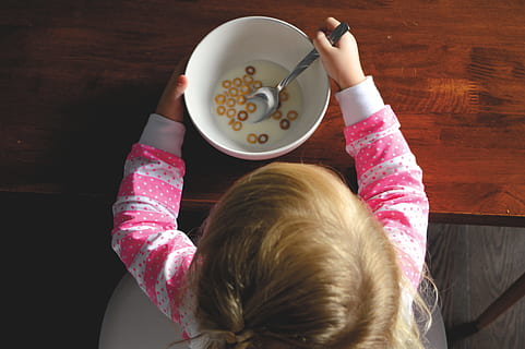 girl, eating, cereal, white, ceramic, bowl, table, baby, holding, spoon, inside, room, child, caucasian Ethnicity, one Person, food, people, females, indoors, women, girls, children only, one girl only, childhood, human arm, food and drink, real people, high angle view, directly above, lifestyles, rear view, sitting, headshot, leisure activity, innocence, breakfast, 5K, CC0, public domain, royalty free