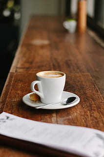 teacup på tallerken, hvid, keramisk, krus, underkop, ske, bord, kop, cookie, biscotti, kaffe, cafe, kaffebar, træ-, latte, restaurant, træ, skrivebord, kop kaffe, kaffe - drikke, mad og drikke, kaffekop, drikke, porcelæn, forfriskning, træ - materiale, stilleben, spise redskaber, køkkenredskaber, indendørs, skummende drikke, fokus på forgrunden, ingen mennesker, koffein, alkoholfri drikkevare, 2K, CC0, offentligt domæne, royaltyfrie