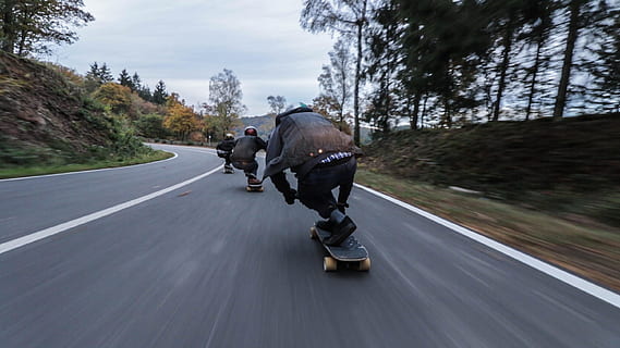 tres, persona, muntar a cavall, monopatins, costa avall, durant el dia, grup, gent, longboard, carretera, transport, a l'aire lliure, velocitat, dia, moviment, passeig, moviment borrós, persones reals, esport, activitat, homes, en moviment, casc, longitud completa, arbre, naturalesa, vista del darrere, 2K, CC0, domini públic, lliure de regalies